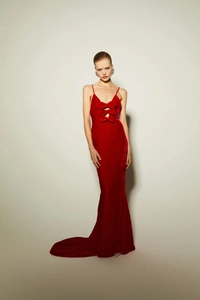 Détail d'une robe de soirée rouge élégante avec nœud décoratif et découpe raffinée