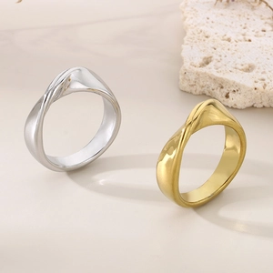 Close-up of irregular twisted wave rings in polished gold and silver stainless steel finishes