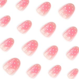 Pink blush gradient press-on nails with white polka dots and glossy round finish