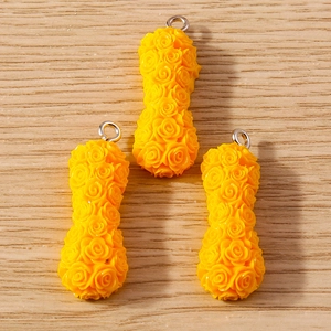 Macro detail of yellow resin rose charms with silver loops for DIY jewelry making