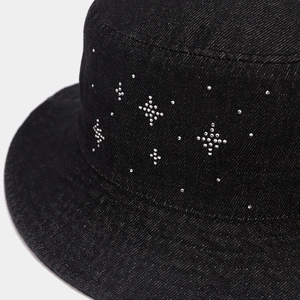 Detail of black denim bucket hat with silver rhinestone geometric patterns and fabric texture