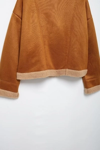 Detail der braunen Wildlederjacke mit Lammfellsaum und strukturierten Ärmelbündchen