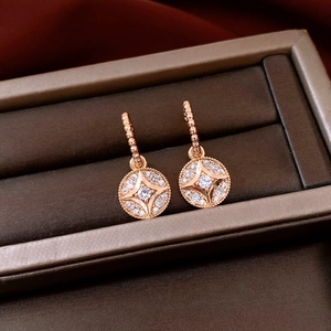 Close-up of rose gold plated round earrings with star pendant in luxury jewelry box