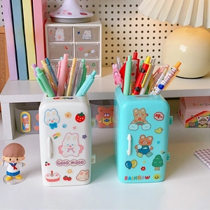 Close-up of cute refrigerator-shaped pen holders in white and teal with cartoon stickers