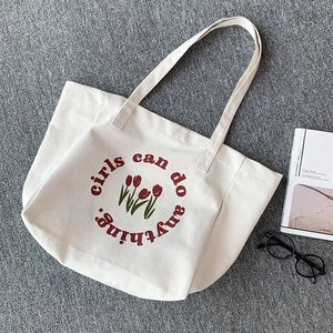 Close-up of thick canvas tote bag with tulip print and girls can do anything text