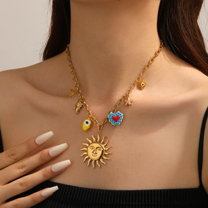 Detailansicht der Goldkette mit Sonnenmaske, bösem Auge und Herz-Charm-Anhängern