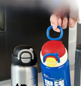 Close-up of stainless steel insulated bottle with dual-drink lid and carry handle