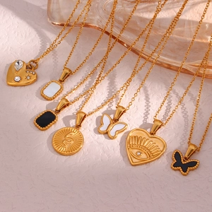 Detail of gold-plated stainless steel necklaces with butterfly and evil eye pendants