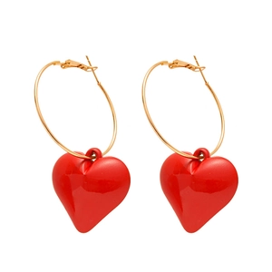 Red heart pendant earrings with gold hoops on a clean white background