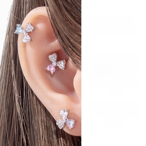 Detail showing three-petal heart zircon flower cartilage earrings on a female ear
