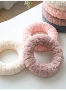 Detail view of plush handmade Christmas wool felt wreaths in four soft pastel colors