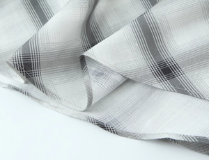 Macro shot of grey and white plaid fabric showing fine woven texture and stitching details