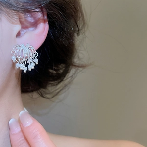 Detailed close-up showing the elegant firework design earrings with pearls on ear