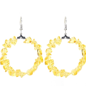 Macro detail of yellow crystal chips on silver hoop earrings with translucent stones