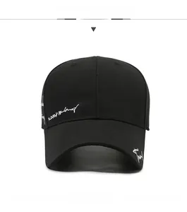 Detail of white cursive embroidery on a premium black cotton baseball cap surface
