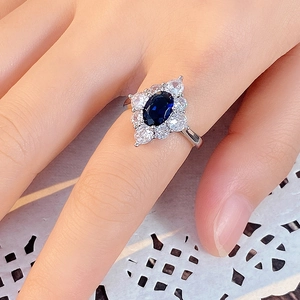 Detailaufnahme eines königsblauen ovalen Edelsteinrings mit diamantenen Blütenblättern