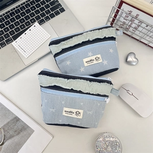 Minimalist patchwork denim cosmetic organizer pouch with frayed edges and star pattern