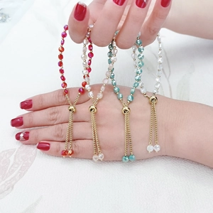 Dettaglio di braccialetti regolabili in oro 18K con perline di cristallo sfaccettate