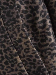 Macro shot of faux fur leopard print fabric with detailed dark brown animal patterns
