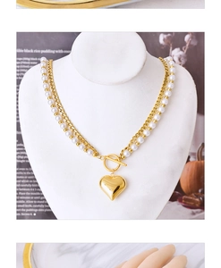 Detail of double-layer pearl necklace with gold heart pendant and OT toggle clasp closure