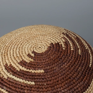 Dettaglio della trama a spirale bicolore in paglia di rafia intrecciata a mano del cappello
