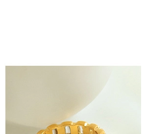 Vue macro d'une bague dorée texturée bambou avec des bords dentelés sur fond blanc