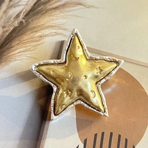 Vue détaillée d'une broche étoile vintage avec motif lune et bordure argentée