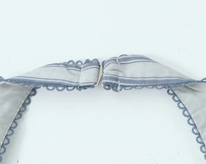 Detail of blue and white striped straps with metal hook buckle and lace trimming