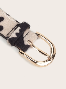 Detailed macro view of the gold D-ring buckle and animal print pony hair texture belt