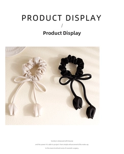 Detailed view of satin bow scrunchies with elegant tulip pendants in black and cream