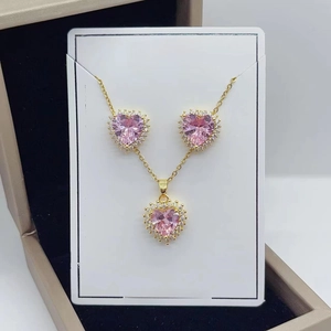 Close-up of pink heart-shaped crystal necklace and earrings set with gold-plated finish
