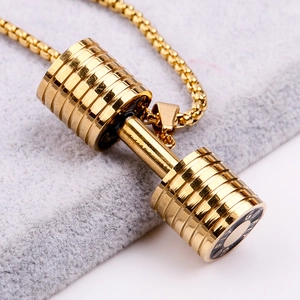 Close-up of golden dumbbell pendant with polished metallic finish on gray fabric