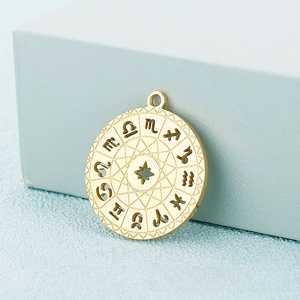 Detail of a golden zodiac pendant with hollow star and engraved astrological symbols