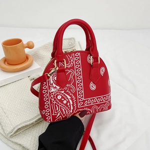 Close-up of red paisley shell bag with gold hardware and detachable shoulder strap