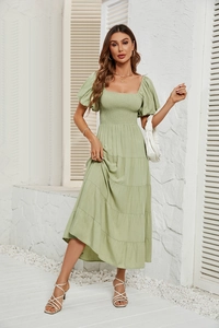 Détails du buste froncé et manches bouffantes sur robe midi vert sauge à volants