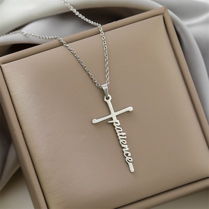 Silver stainless steel cross necklace with patience engraving on elegant beige jewelry box
