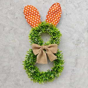 Detail of Easter bunny wreath with green artificial leaves and orange polka dot ears
