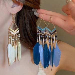 Detailed view of bohemian feather drop earrings with colorful beads and tassels
