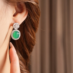 Gros plan sur une boucle d'oreille vintage en calcédoine verte et zircons fleuris