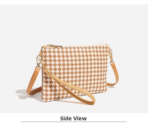 Detail view of woven houndstooth pattern bag with brown leather trim and gold hardware