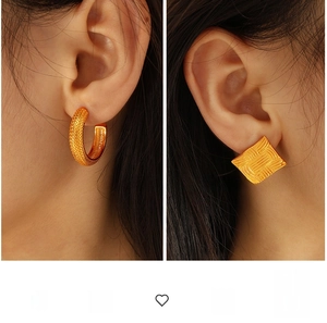 Detailed view of gold C-shaped earrings and square studs with vintage textures on model