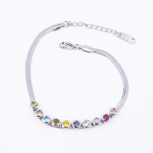 Detailed macro view of silver snake chain bracelet featuring vibrant multi-color gemstones