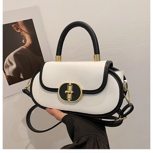 Borsa a mano minimalista in pelle bianca con bordi neri e chiusura dorata tenuta a mano