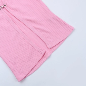 Détail du cardigan en maille côtelée rose avec plumes d'autruche de luxe et boucle métallique