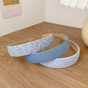 Three-piece French floral and checkered headband set in blue fabrics on a wooden table