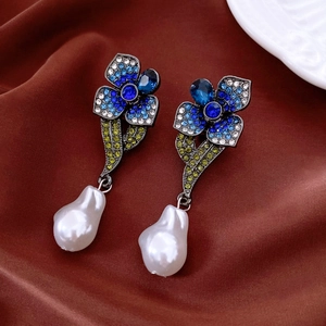 Vue détaillée de boucles d'oreilles vintage avec strass bleus et perle pendante