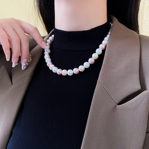 Close-up of elegant multi-color pearl necklace with white, pink, and champagne pearls