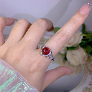 Close-up of vintage silver ring with red ruby stone and sparkling zircon accents
