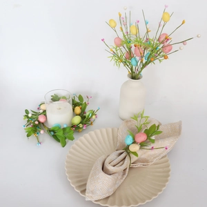 Set decorativo pasquale con rami di uova pastello e anelli per candele sulla tavola