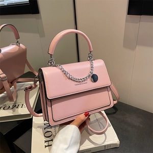 Elegant pink structure handbag with silver chain and top handle on a minimal background